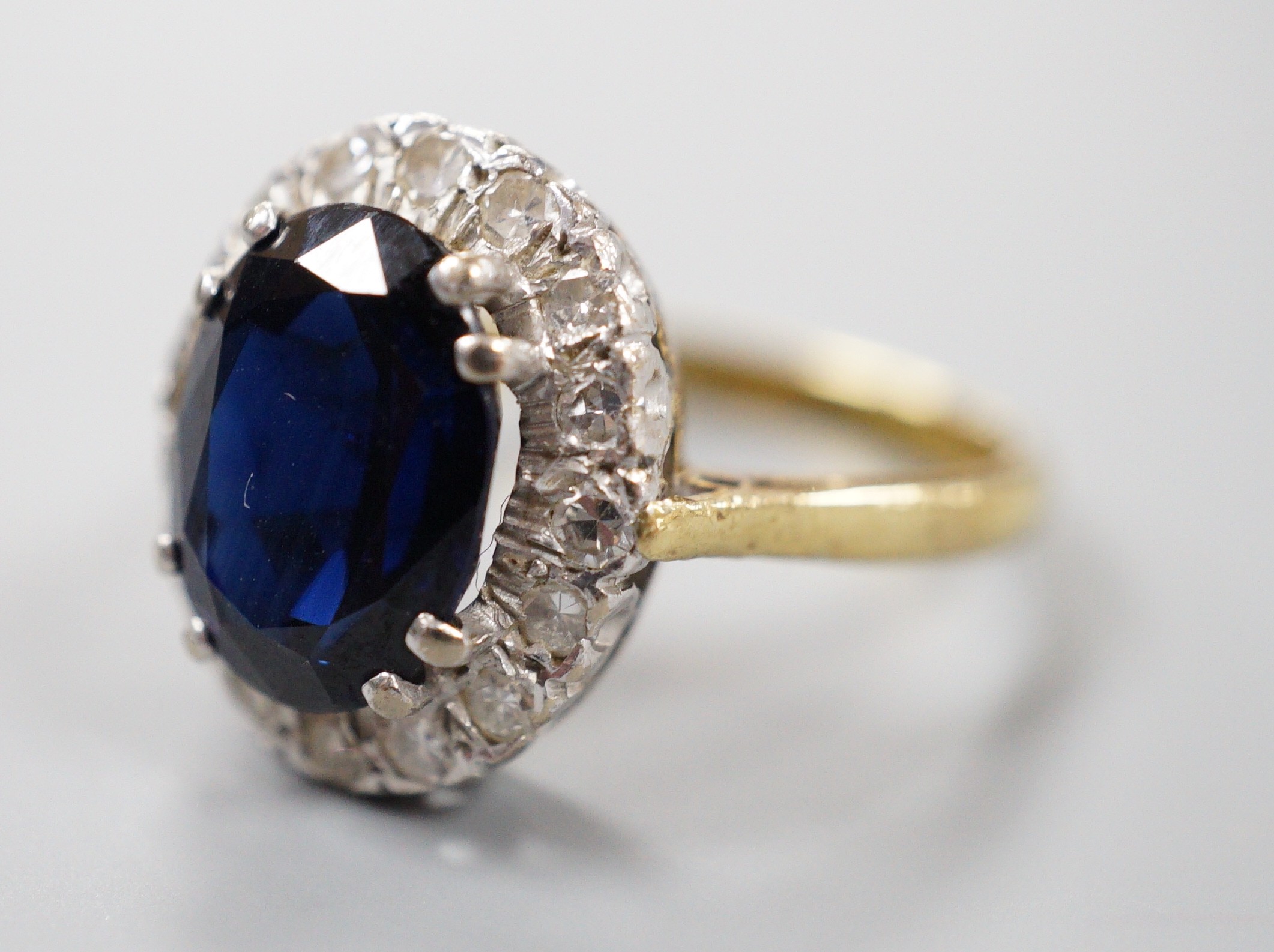 A modern 18ct gold, sapphire and diamond set oval cluster ring, size M, gross weight 4.9 grams.